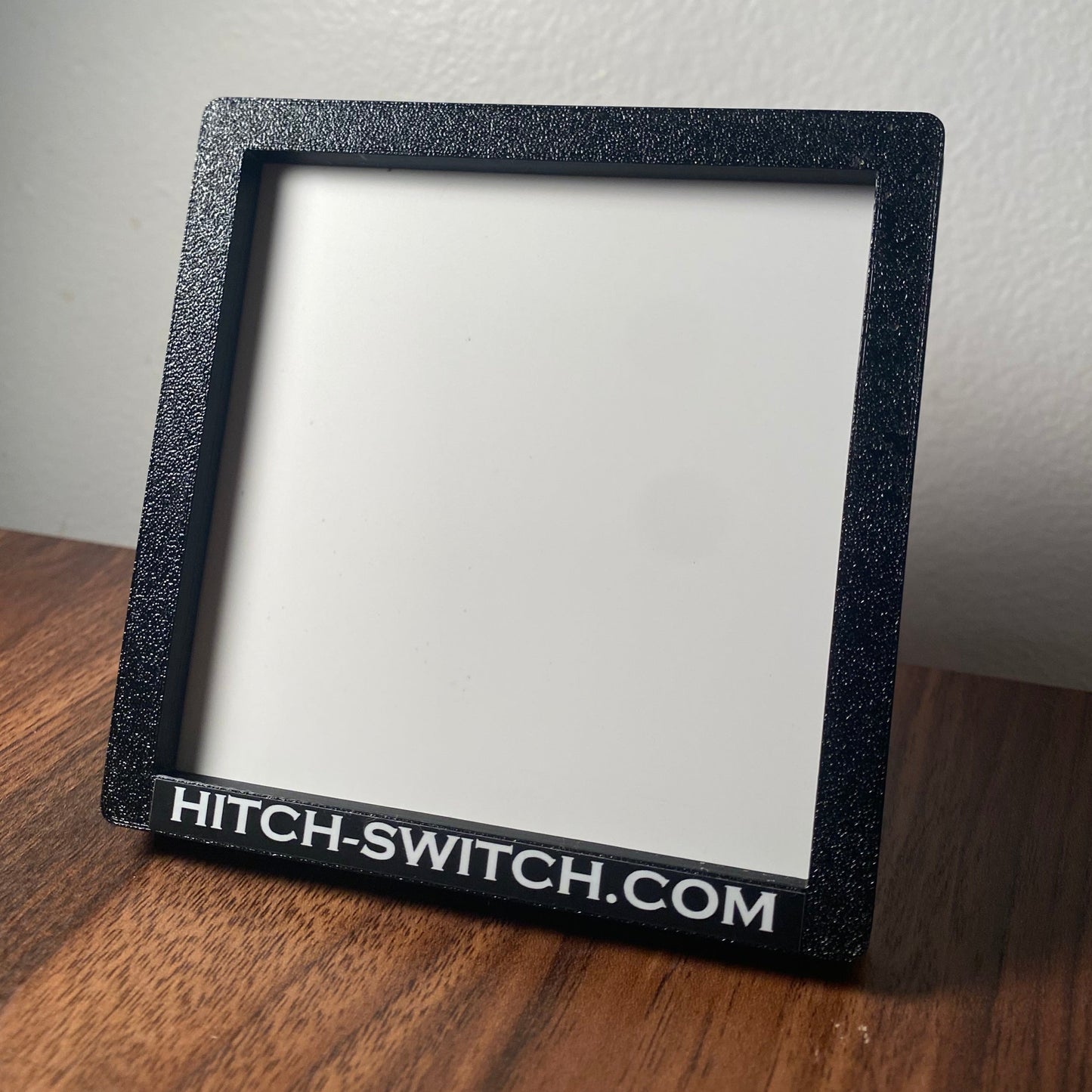 Hitch Switch Car Magnet product on a wooden surface with a neutral background and white design insert for show.