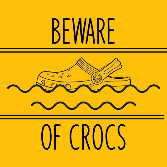 Warning sign with a croc shoe and text 'Beware of Crocs' on a yellow background