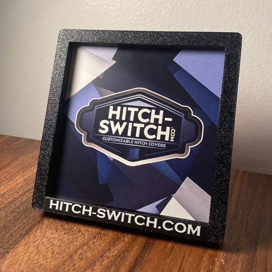 Hitch Switch Car Magnet product on a wooden surface with a neutral background